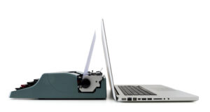 An electric typewriter next to a laptop illustrates analog vs digital