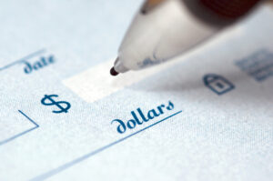 A closeup of a pen hovering over the dollar figure box of a check.