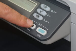 close up of a fax machine. someone presses a button to send a fax.